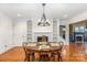 Bright dining room with hardwood floors, modern chandelier, fireplace, and built-in shelving at 4467 Woodlark Ln, Charlotte, NC 28211