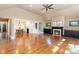 Open-concept living room with hardwood floors, a fireplace, and views into the dining room and stairway at 4467 Woodlark Ln, Charlotte, NC 28211