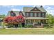 Charming two-story home featuring a beautifully landscaped yard and inviting front porch at 5047 Victory Trl, Gastonia, NC 28056
