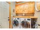 Functional laundry room with wooden cabinets, counter space, and modern washer and dryer units at 5047 Victory Trl, Gastonia, NC 28056