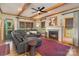 Inviting living room featuring wooden beams, a stone fireplace, and comfortable leather seating at 5047 Victory Trl, Gastonia, NC 28056