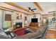 Inviting living room featuring wooden beams, a stone fireplace, and comfortable leather seating at 5047 Victory Trl, Gastonia, NC 28056