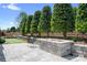 Beautiful backyard with a stone fire pit, putting green, privacy trees, and a seating area; great for entertaining outdoors at 5103 Looking Glass Trl, Denver, NC 28037