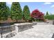 Backyard landscaping with a built-in stone fire pit and beautiful ornamental trees at 5103 Looking Glass Trl, Denver, NC 28037