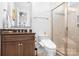 A modern bathroom with a glass enclosed shower and dark wood vanity, offering a sleek design at 5103 Looking Glass Trl, Denver, NC 28037