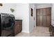 A laundry room with ample storage cabinets and a black front load washer and dryer at 5103 Looking Glass Trl, Denver, NC 28037
