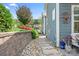 Picturesque side yard featuring a stone pathway, retaining wall, vibrant landscaping, and complementary exterior paint on the house at 5103 Looking Glass Trl, Denver, NC 28037