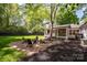 Landscaped backyard features a fire pit area, porch and lawn at 5218 Addison Dr, Charlotte, NC 28211