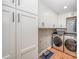 Bright laundry room offers modern washer, dryer, folding counter, storage at 5218 Addison Dr, Charlotte, NC 28211