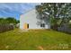 Backyard featuring lush green lawn, privacy fence, and house exterior with light gray siding at 5219 Biederbeck Dr, Charlotte, NC 28212