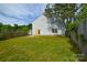 Spacious backyard with lush green grass, privacy fence, and home exterior featuring a light gray siding at 5219 Biederbeck Dr, Charlotte, NC 28212