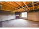 Basement with exposed ceiling beams, fireplace, and large window at 5219 Biederbeck Dr, Charlotte, NC 28212