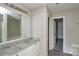 Bathroom featuring double sinks, a large mirror, vanity lighting, and a door leading to a closet at 5219 Biederbeck Dr, Charlotte, NC 28212