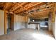 Unfinished living room area with exposed wooden beams, and a sink area, with partial drywall visible at 5219 Biederbeck Dr, Charlotte, NC 28212