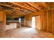 Unfinished living room with exposed wooden beams, sliding glass door, with sink area and partial drywall visible at 5219 Biederbeck Dr, Charlotte, NC 28212