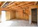 Unfinished living room with exposed wooden beams, a sliding glass door, with a doorway to the left at 5219 Biederbeck Dr, Charlotte, NC 28212