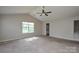 Large, carpeted main bedroom with vaulted ceiling, ceiling fan, and a bright window. Doorway visible in corner at 5219 Biederbeck Dr, Charlotte, NC 28212