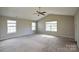 Large, carpeted main bedroom features a vaulted ceiling, ceiling fan, and bright natural light from multiple windows at 5219 Biederbeck Dr, Charlotte, NC 28212