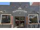 Unique restaurant exterior with a gray brick facade, artistic signage, and outdoor seating area at 650 Raphael Pl, Charlotte, NC 28205