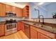 Well-lit kitchen featuring stainless steel appliances, wood cabinets, and granite countertops at 650 Raphael Pl, Charlotte, NC 28205