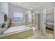 Bright bathroom featuring a soaking tub, glass-enclosed shower, and tile flooring at 7123 Meyer Rd, Fort Mill, SC 29715
