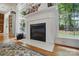 Cozy fireplace with decorative mantel and white tile, framed by windows for natural light at 7417 Chidley Dr, Charlotte, NC 28269