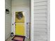 Close-up of a bright yellow front door with a wreath and 'Home Sweet Home' sign at 7417 Chidley Dr, Charlotte, NC 28269