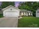 Charming single-story home with a well-manicured lawn, attached garage, and inviting front porch with rocking chairs at 7417 Chidley Dr, Charlotte, NC 28269
