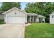 Charming single-story home with a well-manicured lawn, attached garage, and inviting front porch with rocking chairs at 7417 Chidley Dr, Charlotte, NC 28269