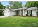 Charming single-story home with a well-manicured lawn and an inviting front porch with rocking chairs at 7417 Chidley Dr, Charlotte, NC 28269
