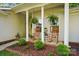 Inviting front porch with rocking chairs, hanging ferns, and lush landscaping at 7417 Chidley Dr, Charlotte, NC 28269