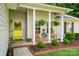 Inviting front porch with rocking chairs, hanging ferns, and a bright yellow door at 7417 Chidley Dr, Charlotte, NC 28269