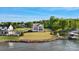 Waterfront home showcasing an expansive lawn, pier, and beautiful lake views on a sunny day at 7679 Rabbit Cir, Denver, NC 28037