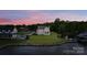 Sprawling backyard on the water with a patio, pool, and private dock, all surrounded by lush greenery and open sky at 7679 Rabbit Cir, Denver, NC 28037