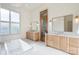 Bright bathroom features double vanities, tub under a window, and stylish tile flooring at 7679 Rabbit Cir, Denver, NC 28037