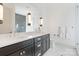 Modern bathroom features a double vanity, sleek lighting, and a glass-enclosed shower at 7679 Rabbit Cir, Denver, NC 28037