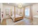 Charming bedroom with a four-poster bed, decorative chandelier, and hardwood floors at 7679 Rabbit Cir, Denver, NC 28037