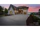 Stunning exterior view of a home with three-car garage and a beautiful sunset at 7679 Rabbit Cir, Denver, NC 28037