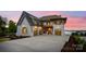 Stunning waterfront home with painted brick, copper accents, and a three-car garage at sunset at 7679 Rabbit Cir, Denver, NC 28037