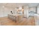 Well-lit kitchen with an oversized island, hardwood floors, and custom fixtures at 7679 Rabbit Cir, Denver, NC 28037
