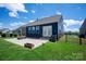 Relaxing backyard with a paved patio featuring a fire pit and a lush green lawn at 8000 Millbridge Pkwy, Waxhaw, NC 28173