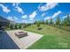 Well-manicured backyard with a paved patio featuring a fire pit and sloping lawn at 8000 Millbridge Pkwy, Waxhaw, NC 28173