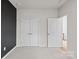 Neutrally painted room with plush carpet, and doorway and closet door leading to a hallway at 8000 Millbridge Pkwy, Waxhaw, NC 28173