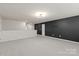 Open bonus room with neutral carpet, modern lighting, and an accent wall at 8000 Millbridge Pkwy, Waxhaw, NC 28173