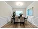 Elegant dining room with wainscoting, modern light fixture, and large window for natural light at 8000 Millbridge Pkwy, Waxhaw, NC 28173