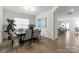 Stylish dining area showcasing wainscoting, wood floors, and seamless transition to the kitchen at 8000 Millbridge Pkwy, Waxhaw, NC 28173