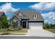 Charming single-Gathering home with a stone facade and a two-car garage against a bright blue sky at 8000 Millbridge Pkwy, Waxhaw, NC 28173