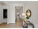 Light-filled hallway with neutral paint, white trim, wood flooring, and an elegant console table at 8000 Millbridge Pkwy, Waxhaw, NC 28173