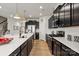 Spacious kitchen featuring dark cabinets, a large island, stainless steel appliances, and modern lighting at 8000 Millbridge Pkwy, Waxhaw, NC 28173