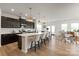 Open-concept kitchen featuring dark cabinetry, a large island with seating, and modern pendant lights at 8000 Millbridge Pkwy, Waxhaw, NC 28173